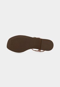 Hnědá pryžová podešev boty má texturované drážky pro lepší přilnavost a oporu, s plochým designem a minimálním zdobením. Viditelné logo Geox.