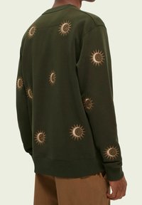 Olivgrüner Sweatshirt mit goldener Sonnen- und Mondstickerei. Hat einen Rundhalsausschnitt, einen lässigen Schnitt und gerippte Bündchen und Saum.