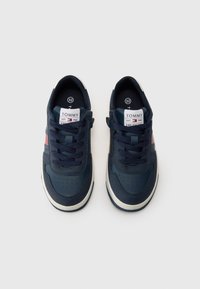 Baskets bleu marine avec semelles blanches, dotées d'un empeigne en cuir texturé, d'une forme arrondie, d'un laçage à l'avant et d'un petit logo de la marque sur la languette.