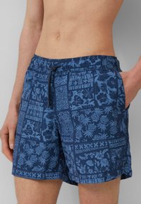 Námornícke modré plavky s patchwork dizajnom kvetinových a ananásových vzorov, s elastickým pásom a šnúrkou.