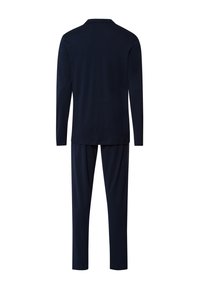 Tummansininen yhdenmukainen pyjamapuku, joka on valmistettu pehmeästä kankaasta ja jossa on pitkät hihat ja rento istuvuus. Ei näkyviä kuvioita tai korostuksia.