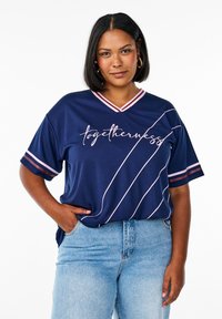 Navy blue athletic-style t-shirt with short sleeves, v-neck, pink accents, and white text "togetherness" and diagonal stripes. Denim jeans.
