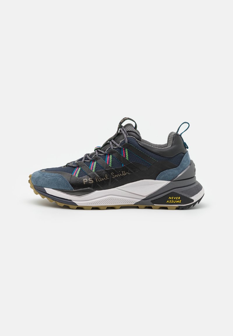 Baskets gris foncé et bleues avec des rayures multicolores, logo PS Paul Smith, semelle épaisse, et texte jaune "Never Assume" sur le talon.