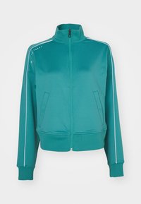 Rjava zip-up jakna s visokim ovratnikom, dvema stranskima žepoma, belimi stranskimi črtami in rebrastimi manšetami. Narejena iz gladkega, teksturiranega blaga.