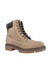 Stivaletto in suede color sabbia con dettaglio in pelle nera, occhielli dorati e lacci scuri, caratterizzato da una suola in gomma spessa con scanalature profonde per una buona aderenza.