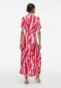 Vestido maxi en un patrón abstracto rojo y rosa, con mangas cortas, cinturón en la cintura, tejido fluido, textura suave, diseño hasta los tobillos.