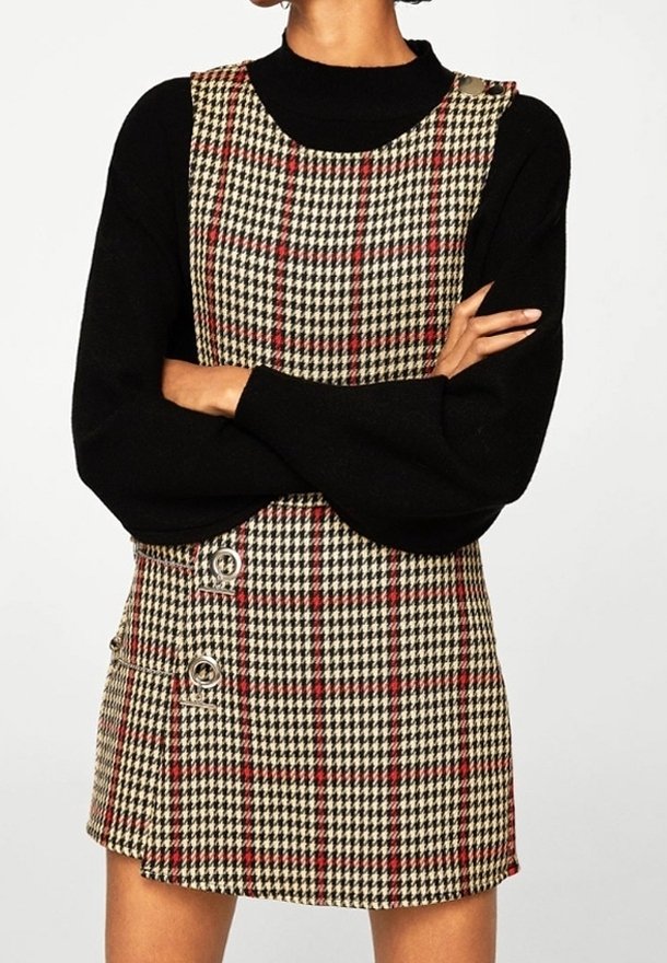 Ruudullinen minimekko beige, musta ja punainen sävyssä. Ominaisuudet neliömäinen kaula-aukko ja kaksi hopeista metallipainiketta sivussa. Teksturoitu kangas.