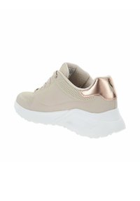 Zapatilla beige con un frontal texturizado, lado perforado y un acento metálico en rosa oro en el talón. Presenta una suela de goma blanca y cordones.
