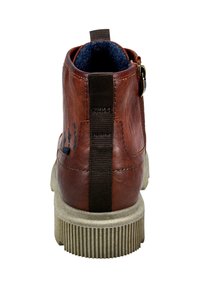 Braune Lederstiefelette mit einer strukturierten, hellgrauen Sohle. Mit einem hinteren Riemen für einfaches Anziehen und einem blauen Stofffutter.