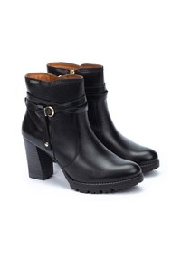 Botas negras de cuero hasta el tobillo con punta redonda y tacón de bloque. Incluyen una correa decorativa con hebilla y una suela texturizada.