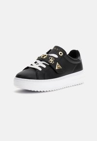 Schwarze Leder-Sneaker mit weißen Schnürsenkeln, goldenen Hardware-Akzenten und einer strukturierten weißen Sohle. Mit dreieckigem Logodetail an der Seite.