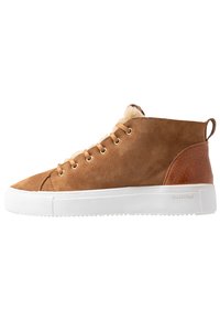 Brown suede high-top sneaker with white rubber sole, lace-up front, gold eyelets, and tan leather accents on the heel. Soft lining visible at the top.