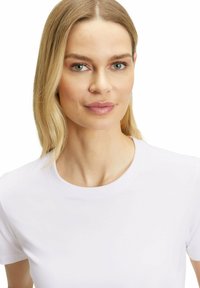 Witte t-shirt met ronde hals en korte mouwen, gemaakt van een gladde stof. De halslijn is afgewerkt met een eenvoudige stiknaad.