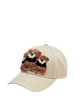 Gorra de béisbol beige con caras de mapache bordadas en marrón y blanco, con textura, en el panel frontal.