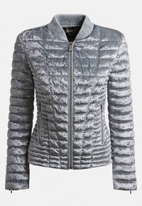 Veste courte en velours matelassé gris argenté avec col côtelé, fermeture éclair à l'avant et poches latérales zippées, présentée sur fond blanc.