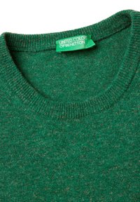 Zelený svetr s kulatým výstřihem a zelenou nálepkou s nápisem "United Colors of Benetton" přišitým na vnitřním límci.