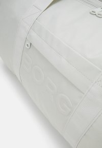Jasnoszara torba sportowa wykonana z durable fabric. Posiada wytłoczone logo "BORG", mocne paski i zamek błyskawiczny. Teksturowana powierzchnia, minimalistyczny design.
