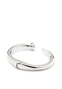 Bracelet manchette en argent avec une finition lisse et polie, présentant un design ouvert distinctif et un détail d'extrémité pointue, fabriqué en métal.