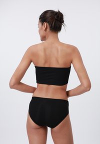 Svart, ribbete bikini-sett med et stroppeløst topplag og høyt liv-bunn, med en jevn tekstur og en tettsittende design.