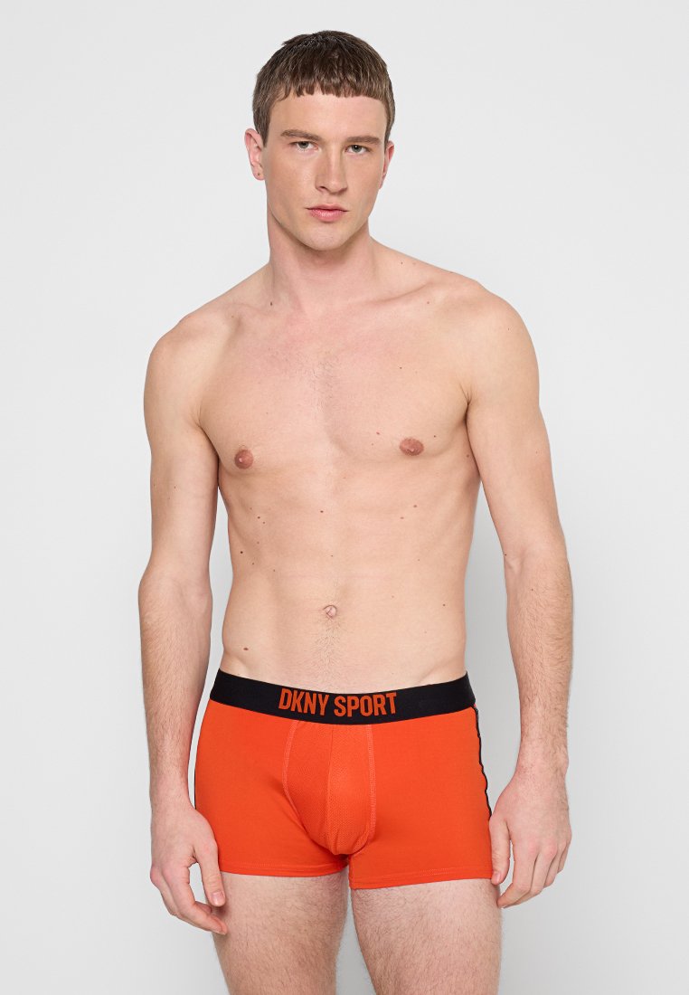 Rote DKNY Sport Herrenboxershorts mit schwarzem Bund, auf dem "DKNY SPORT" in Orange steht. Stretchstoff mit taillierter Passform.
