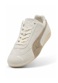 Białe zamszowe sneakersy z teksturowanym brązowym akcentem z boku, okrągłymi sznurówkami i gumową podeszwą w kolorze gumy z delikatnym logo.