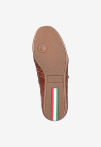 Semelle de chaussure en cuir marron avec une surface texturée antidérapante, détail circulaire au talon, et une bande aux couleurs du drapeau italien courant verticalement près du talon.