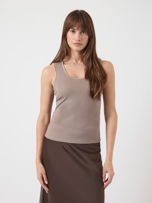 Débardeur marron à côtes avec un col scoop, associé à une jupe marron. Le tissu semble doux et extensible, offrant une silhouette ajustée.
