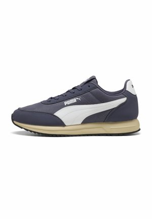 Marineblauer Puma-Sneaker mit weißem Formstrip-Logo, beiger Sohle, Schnürverschluss vorne und schwarzer profilierten Außensohle, seitlich auf weißem Hintergrund dargestellt.
