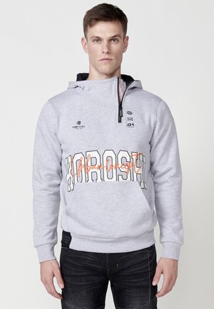 Sudadera gris con capucha, que presenta un estampado gráfico en naranja y negro "Concepto Urbano" en la parte delantera, y cierre de cuello con cremallera.