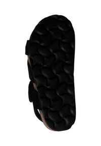 Semelle de chaussure en caoutchouc noir avec un motif texturé et ondulé ; équipée de sangles ajustables. La semelle est légèrement cintrée sur les bords pour plus de confort.