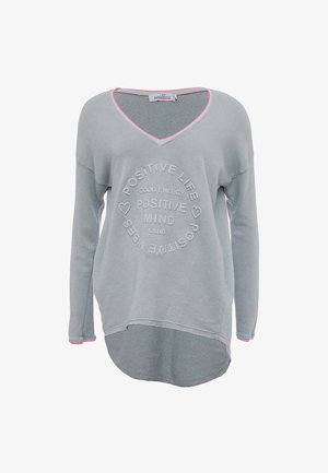 Lys grå langærmet pullover med V-hals, der har prægede bogstaver i et cirkulært mønster og lyserød kant langs halsudskæringen og kanten.