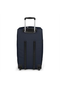 Námořnická modrá kolečková taška vyrobená z textilie, vybavená teleskopickou rukojetí, hladkými koly a zpevněnými černými plastovými akcenty.