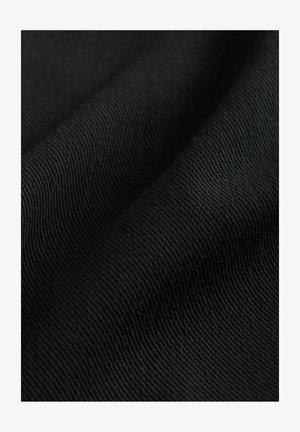 Črno blago z gladko, strukturirano površino, ki prikazuje diagonalne tkanine, prikazano v blagih gubah.