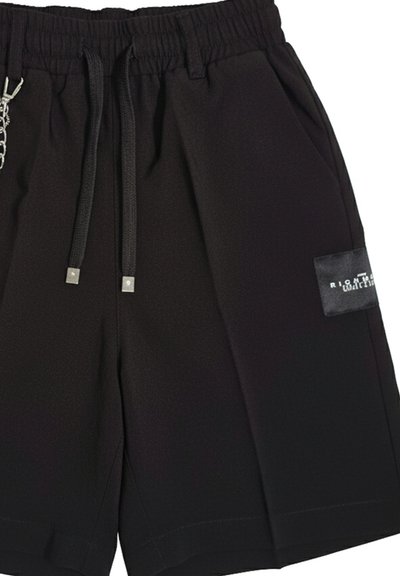 Pantaloncini casual neri con vita elastica, coulisse nere con punte in metallo, tasche laterali e una piccola etichetta nera sulla gamba destra.