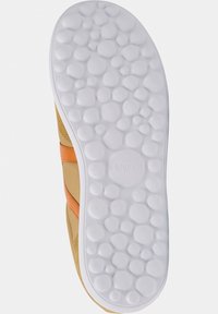Suela de zapato Camper, con una parte inferior de goma blanca texturizada con bultos redondeados. La parte superior es de color marrón claro con una franja de acento naranja.