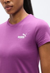 Μωβ βαμβακερό μπλουζάκι με κοντά μανίκια, που διαθέτει λευκό λογότυπο Puma στην αριστερή πλευρά του στήθους. Λείο ύφασμα και κλασικός στρογγυλός γιακάς.