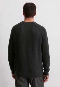 Dunkelgrauer Strickpullover mit gerippter Textur, Rundhalsausschnitt und langen Ärmeln, von hinten gezeigt, kombiniert mit gestreiften grauen Hosen.