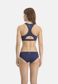 Sportliches Bikini-Set in Marineblau, mit einem Racerback-Oberteil mit Ausschnittdetails und passendem Höschen mit weißem Logoakzent. Glattes, elastisches Material.