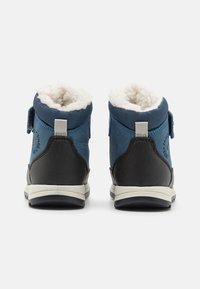 Bottes d'hiver bleu et noir avec une finition texturée, doublure en crème douce, sangle ajustable et semelle en caoutchouc pour une bonne adhérence.