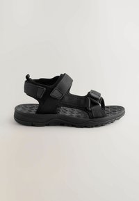 Svarta sandaler med en ventilerande textilöverdel, justerbara remmar, strukturerad sula och en stadig design för komfort och stöd.