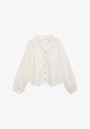 Blusa bianca con maniche lunghe e svasate, scollatura rotonda e chiusura a bottoni, con cuciture decorative lungo il corpetto.