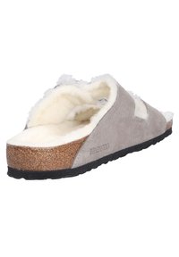 Sandalo scivoloso in suede grigio con rivestimento in shearling bianco, soletta in sughero e suola in gomma nera. Presenta lati intagliati e dettagli del marchio.