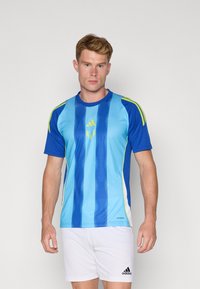 Blå og lyseblå sports trøje med lodrette striber, korte ærmer og grønne detaljer. Har Adidas-logo på brystet.