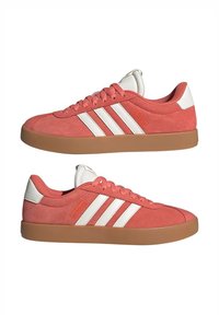 Koralske nubuk tenisice s bijelim trakama i detaljima, s gumenim potplatom, okruglim vrhom i dizajnom s vezicama.