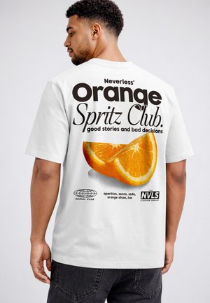 Mann trägt weißes T-Shirt mit dem Text "Neverless Orange Spritz Club" und großem Orangenscheiben-Grafik auf dem Rücken.