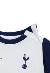 Witte sporttrui met marineblauwe accenten. Voorzien van een ronde halslijn, drukknoopjes en een Tottenham Hotspur-logo op de voorkant. Gestructureerde stof.