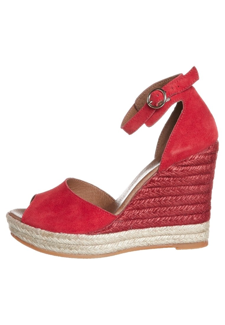 Sandale compensée en daim rouge avec un bout ouvert, une bride pour la cheville avec boucle, et des accents de talon en jute tissé. Design texturé et contraste de couleurs naturelles.