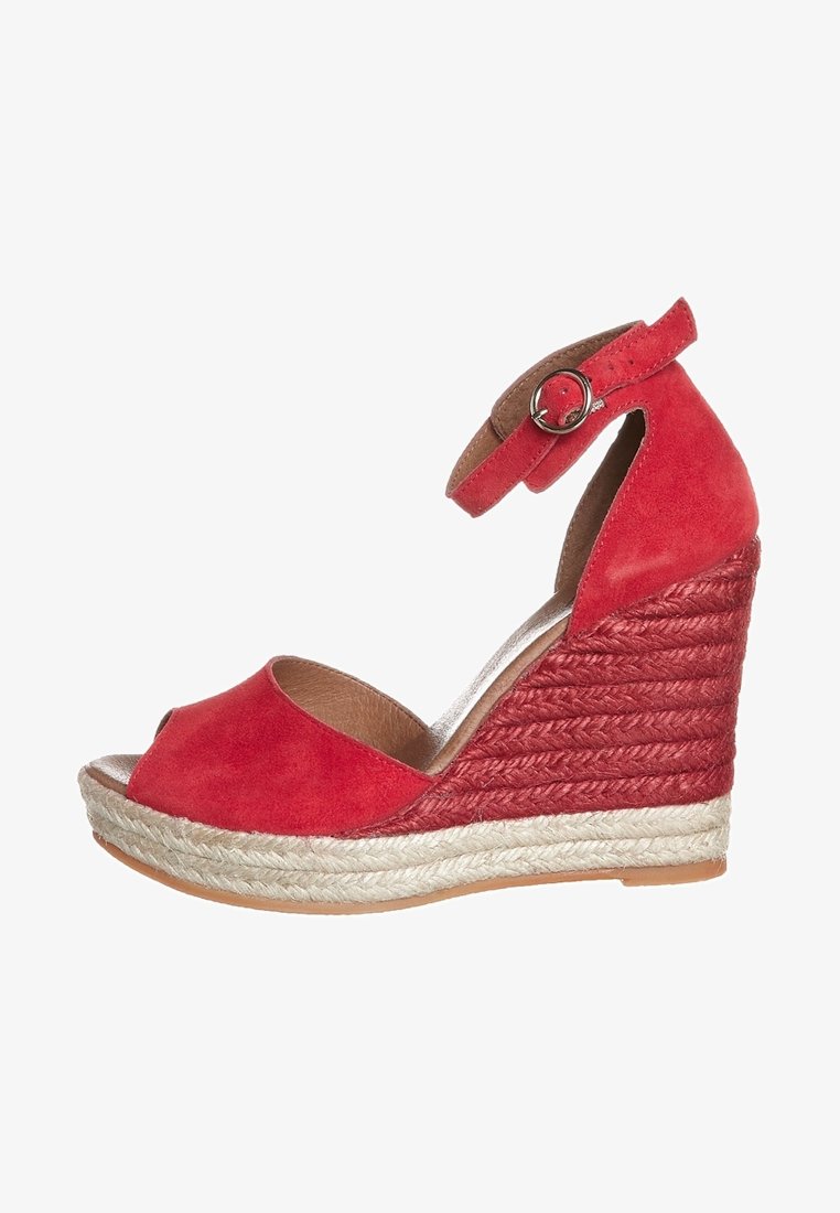 Sandale compensée en daim rouge avec un bout ouvert, une bride pour la cheville avec boucle, et des accents de talon en jute tissé. Design texturé et contraste de couleurs naturelles.