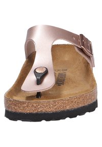 Infradito rosa oro con un cinturino nero e una soletta in sughero. Presenta una soletta interna marrone texturizzata e una suola esterna in gomma nera.