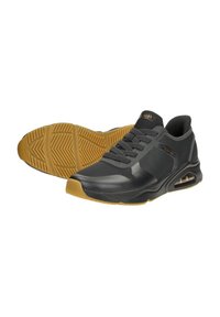 Black athletic shoes with a textured upper, lace-up design, and a visible air cushioning unit. Rubber outsole with traction patterns.